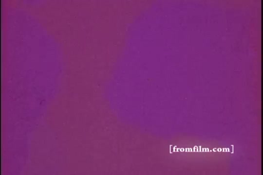 The still features a solid purple background, typical of film stock from the 16mm format. It suggests a stylized or abstract segment from the PSA (Public Service Announcement) focusing on the Israel Emergency Fund. The simplicity of the color may indicate a transition or a title card within the film. There is also a watermark in the corner indicating the source as “fromfilm.com.”