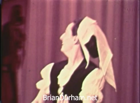 The still from the 'Pittsburgh Folk Festival PSA - 1968' features a dancer in traditional attire, showcasing a vibrant performance. The dancer appears engaged and expressive, with a headpiece that complements the cultural costume. The background hints at a stage setting, aligning with the festival's celebration of folk art and culture. The announcement mentions the event's dates and is presented by Robert Morris Junior College, suggesting community involvement and support for the arts.
