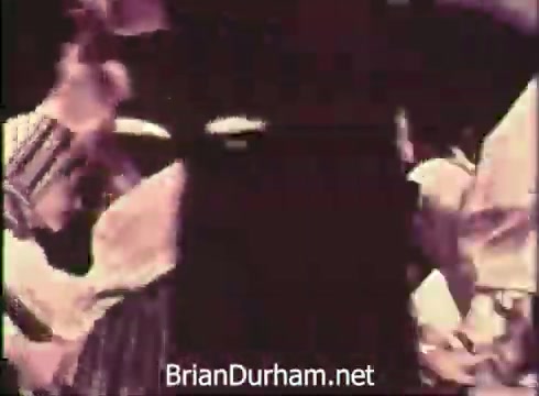 The still from 'Pittsburgh Folk Festival PSA - 1968' features a lively gathering, likely showcasing traditional folk dancing. Participants are dressed in culturally specific attire, indicative of various folk traditions. The context emphasizes the 12th Pittsburgh Folk Festival taking place at the Civic Arena, highlighting the event's focus on cultural heritage and community celebration occurring on June 7th, 8th, and 9th.