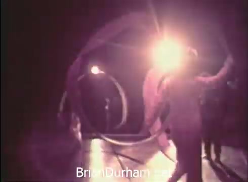 The still features performers in action at the 12th Pittsburgh Folk Festival. Bright lights illuminate the scene, emphasizing dynamic movements and the festive atmosphere. The artistic display likely includes elements of dance and traditional folk performances, set against a stage backdrop that enhances the celebratory tone of the event. The image conveys a sense of energy and cultural vibrancy associated with the festival held at the Civic Arena in June 1968.