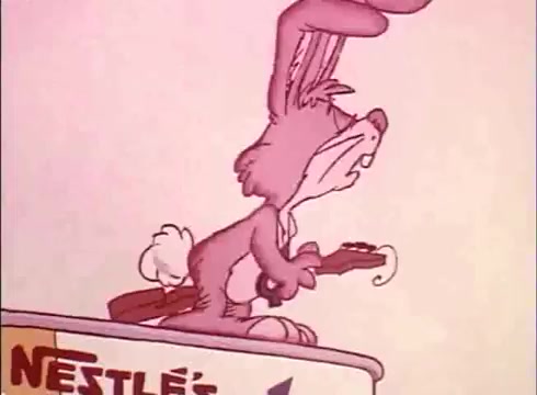 The still from the 1970s/1980s Nestlé Quik commercial features an anthropomorphic cartoon bunny, known as the Quik Bunny, playing a guitar. The character has large ears and a playful expression, and is positioned on top of a sign that reads 'NESTLÉ.' The color palette is soft and pastel, typical of animations from that era. The bunny's collar with a prominent red 'Q' emphasizes its branding. The overall vibe is whimsical, aimed at appealing to children.