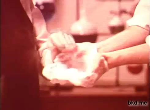 The still from the 'Camay Soap' commercial features two hands, one of which appears to be lathering soap in the other. The scene likely emphasizes the product's luxurious and gentle qualities. The background is reminiscent of a vintage setting, typical of 1970s commercials, with soft colors and a nostalgic aesthetic.