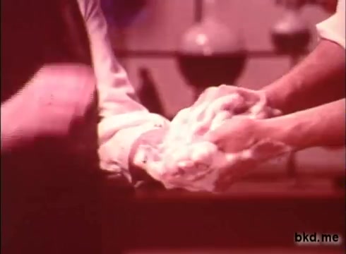 The still from the 'Camay Soap' commercial features two hands lathering up with soap, emphasizing the product's rich lather and cleansing properties. The scene conveys a sense of freshness and care, typical of 1970s advertising aesthetics. The color palette appears warm and vintage, characteristic of the era's film quality.