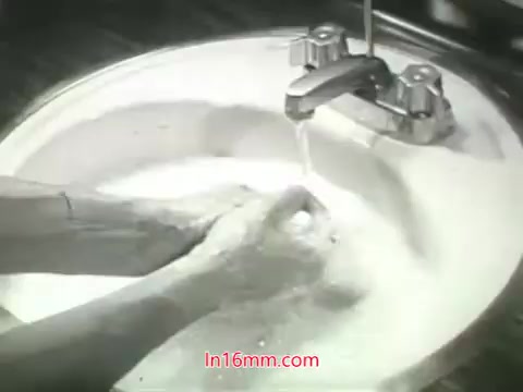 The still from the PSA features a close-up of hands being washed in a sink filled with soapy water. The faucet above is pouring clean water into the basin, creating a visual representation of cleanliness amidst the context of pollution. This image likely symbolizes the idea of washing away dirt and impurities, paralleling the voiceover's message about the challenges of urban air pollution and the importance of taking action for cleaner air. The scene emphasizes the inability to 'wash' internal health issues, such as those affecting the lungs, resulting from polluted environments.