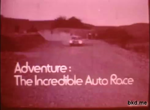 The still features the title 'Adventure: The Incredible Auto Race' prominently displayed at the bottom. The scene depicts a car on a rugged gravel road, suggesting a journey typical of a road rally. The overall color scheme appears faded, indicative of its age as a 16mm print, capturing a vintage cinematic feel. The landscape hints at a remote area, aligning with the adventurous theme of traveling from London to Sydney.
