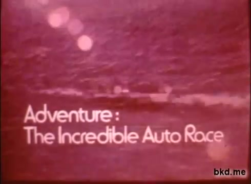 The still features a vintage 16mm film frame promoting 'Adventure: The Incredible Auto Race,' a road rally from London to Sydney. The text appears in a bold, retro font against a textured, reddish background, likely depicting scenic landscapes or a journey. The overall tone evokes the excitement of adventure and exploration during the 1970s.