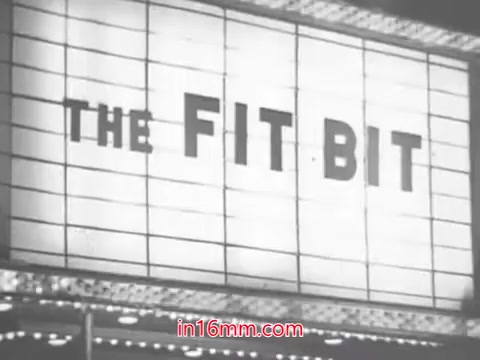 The still features a classic marquee sign that reads 'THE FIT BIT.' The retro aesthetic reflects a 1960s vibe, typical of advertisements from that era. The context suggests a promotional tone, emphasizing the benefits and stylish offerings of Leg Street panty hose. The scene captures the essence of an era focused on fashion and affordability, appealing to a target audience through catchy, rhythmic lyrics.