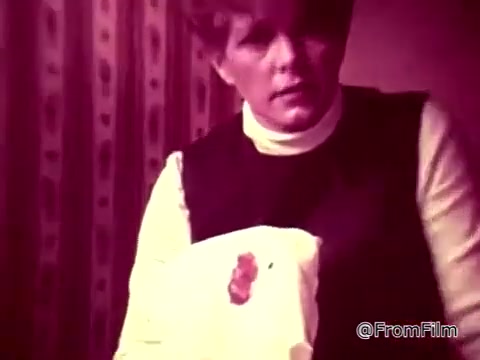 In this 16mm still from the 'Tide XK' laundry detergent commercial, a woman appears concerned as she holds a guest towel stained with a noticeable ketchup spot. The scene conveys urgency, emphasizing that the traditional barriers against tough stains, like ketchup, are being challenged by the new Tide XK detergent. The narration supports this, highlighting the breakthrough in cleaning technology. The overall atmosphere is tense, suggesting that the woman's reputation is at stake due to the stain, with a playful nod to potential consequences from a character named Blanche.