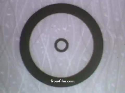 The still from the UPA commercials features a simple yet striking visual composition of concentric circles against a textured background. The design emphasizes the contrast between the various sizes of the rings, creating a sense of depth and movement. This minimalist approach reflects UPA's distinctive animation style, characterized by bold graphics and clean lines. The commercial likely involves an abstract representation related to American Express, utilizing animation to convey a message in a visually engaging way typical of the late 1950s.