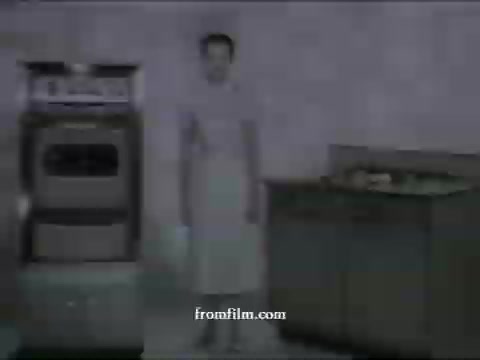 The still from the UPA commercials features a character in a simple kitchen setting, wearing an apron and standing beside a stove and counters. The visual style reflects the animation aesthetics of the late 1950s, showcasing a minimalistic design typical of UPA's work. This particular scene likely promotes American Express, emphasizing a straightforward, clean approach to advertising typical of the period.