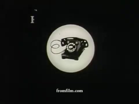 The still features a classic rotary telephone set against a stark black background, enclosed within a circular white graphic. It represents an early American Express commercial from the late 1950s, showcasing UPA's distinctive animation style. The simplicity and bold design reflect the era's advertising aesthetics, focusing on clear imagery to convey the message effectively.