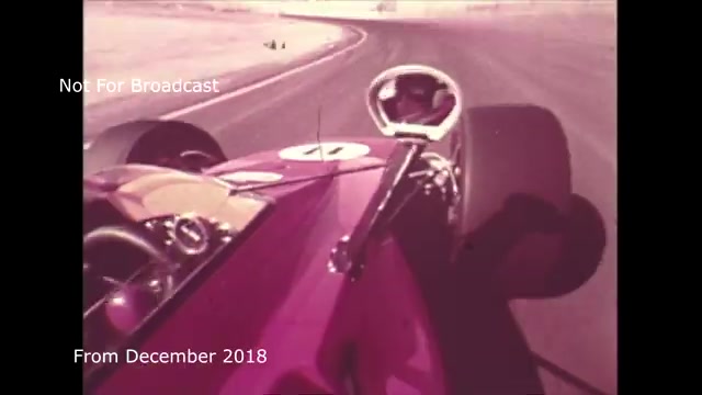 The still from the 'December 2018 transfer talk Chase and Sandborn Commercial' captures a dynamic moment from a race car's perspective, likely emphasizing the excitement of speed and motion. The footage appears to be a vibrant, vintage-style shot, showcasing a pink race car navigating a curve on an empty track. The labels 'Not For Broadcast' and 'From December 2018' indicate that it’s an archival piece intended for a specific audience rather than public viewing.  In your commentary, you mention challenges with audio sync during the transfer from film to video, which you've worked to resolve. This context highlights the technical aspects of preserving and presenting vintage media, underscoring both the creative and logistical efforts involved in the transfer process.