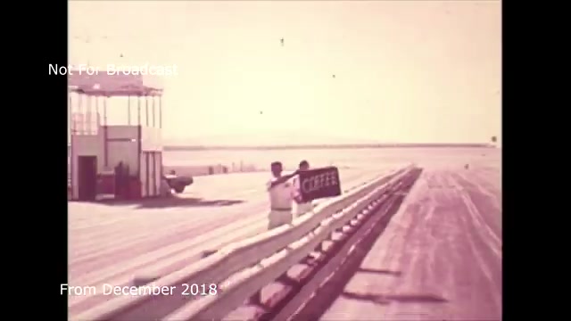 The still from the commercial features a scene at a racetrack or airport runway, with a man in white attire holding a sign that reads 'COFFEE.' In the background, a control tower and vehicles can be seen, suggesting a bustling environment. The overall aesthetic is vintage, reflecting the 16mm film format from 2018. You've noted you encountered audio sync issues during the transfer process from film to video. This archival material represents an interesting glimpse into the production process for the Chase and Sandborn commercial.