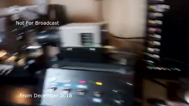 The still captures a scene from a workspace where a 16mm film transfer is taking place. A projector is visible, likely part of the setup for transferring the Chase and Sandborn commercial from film to video. Various equipment is present, indicating the technical nature of the process. There's a sense of nostalgia and a documentary-style atmosphere, reflecting the behind-the-scenes effort involved in film archiving. You note previous audio sync issues, which you've hopefully resolved. The image is dated from December 2018 and carries a 'Not For Broadcast' label, emphasizing its archival nature.