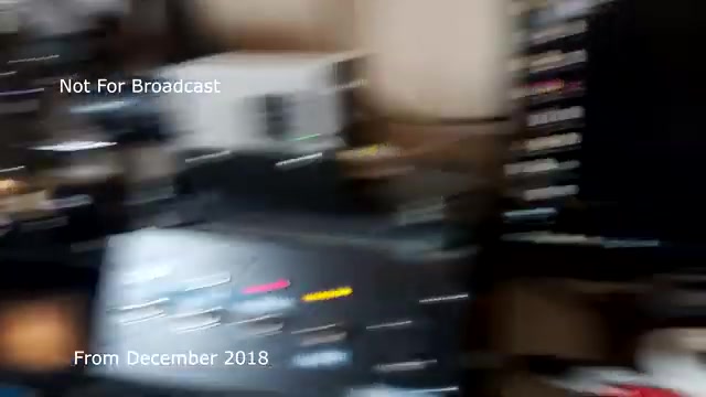 In this still from the 'December 2018 transfer talk' about the Chase and Sandborn commercial, we see a cluttered workstation, indicative of video and audio editing. Various pieces of equipment are visible, suggesting a transfer process from film to video. The focus appears to be on managing audio sync issues while discussing the technicalities involved in the transfer. The label 'Not For Broadcast' further emphasizes that the content is for archival purposes only. Overall, the image captures a moment of behind-the-scenes work in media production.