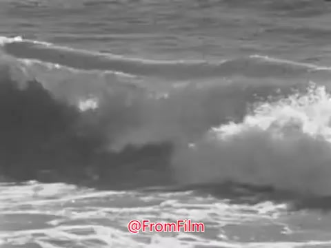 The 16mm still from the 'US Navy Recruiting PSA - 1960's' features a black-and-white close-up of ocean waves crashing against the shore. The imagery evokes a sense of timelessness and nature's power, complementing the voice-over that reflects on the enduring nature of the sea through endless days and nights. This allows for a serene yet powerful connection to the themes of exploration and service that the Navy promotes.