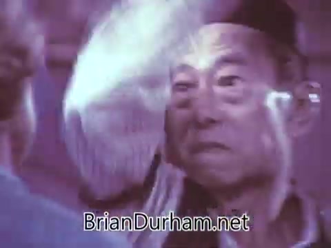 The still features a scene from a 1968 commercial for Red Rose Tea. It appears to depict two characters in an interaction, with a focus on the expressions and emotions exchanged between them. The lighting and color suggest a nostalgic and vintage aesthetic typical of the era’s advertising style. The context implies a cultural or thematic significance, but specific details about the characters or storyline aren't provided.