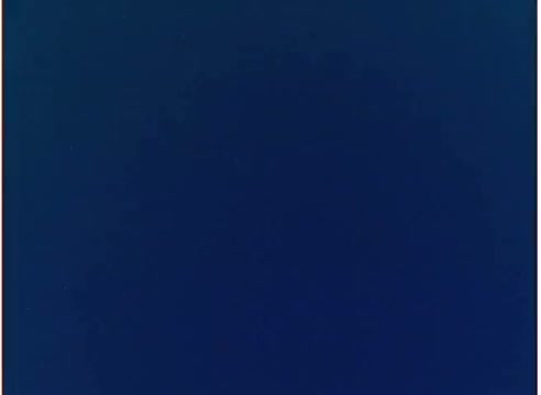 The still features a plain blue background, with no visible subjects or text. It appears to be a frame from a 16mm film negative, possibly part of the visual branding or aesthetic used in the 1970s Mazola corn oil commercial. The simplicity of the image suggests it may have been used for striking visual contrast or to focus on a specific message or product later in the commercial.