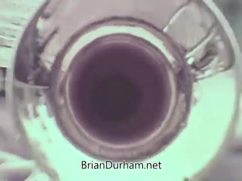 The still appears to show the interior view of a trumpet or brass instrument, emphasizing the circular bell and the reflective surfaces inside. The image suggests a close-up perspective, likely aiming to highlight the instrument's design or sound quality. The focus on the brass could imply themes of music or performance related to the US Navy's public service announcement from 1968.