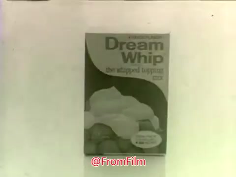 The still features a box of Dream Whip, emphasizing its appeal as a whipped topping mix. The packaging is prominently displayed with bold text identifying the product. The overall aesthetic reflects the typical advertising style of the 1970s, focusing on simplicity and direct presentation to attract potential buyers. The background is minimal, keeping the attention on the product itself.