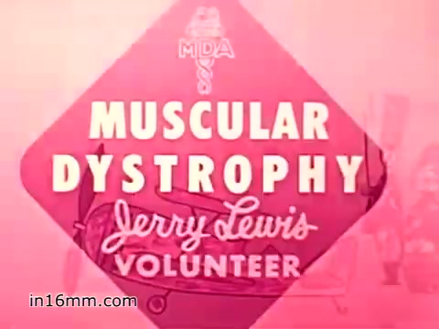 The still from the 1960s animated PSA on Muscular Dystrophy features a bold, diamond-shaped graphic prominently displaying 'MUSCULAR DYSTROPHY' and 'Jerry Lewis VOLUNTEER.' The background is a soft pink, and the design is simple yet impactful, aiming to encourage donations when volunteers come to the door. The imagery reflects the era's style and emphasizes the importance of community support for the Muscular Dystrophy Association.