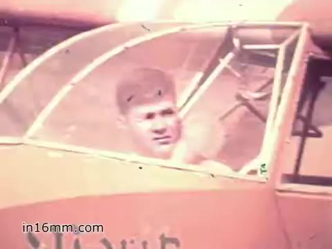 The still from the US Army recruiting PSA 'Your Man in Nürnberg' features a young Specialist Four Joe Naifus sitting in the cockpit of an aircraft. He appears focused and composed, embodying the responsibilities of his role in supply management for the Army. The image reflects a blend of military professionalism and personal engagement, hinting at the complexity of his duties and the vibrant life outside of work, as he explores Nuremberg in his free time. The overall tone emphasizes the valuable skills learned through military service.