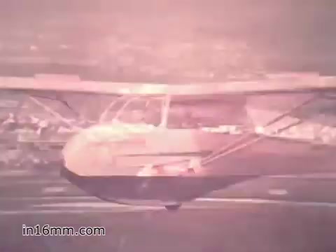 The still from the 1960s US Army recruiting PSA 'Your Man in Nürnberg' features an aircraft in flight, highlighting the dynamic and action-oriented nature of military service. The voiceover mentions Joe Naifus, a Specialist Four in the Army responsible for managing supply logistics. This scene captures the intersection of military duty and personal adventure, illustrating both the complexities of Joe's job and his opportunities for exploration while stationed in Germany.