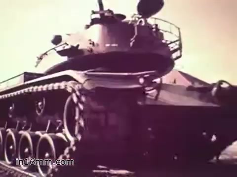 The still from the US Army recruiting PSA 'Your Man in Nürnberg' features a military tank, showcasing its intricate design and robust features. The focus is on the vehicle's functionality and the complexity of military operations, symbolizing the support role of Specialist Four Joe Naifus in maintaining equipment. The overall tone highlights pride in service and the importance of logistics in the army.
