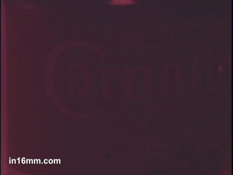 The 16mm still features a close-up view of a can of Carnation Condensed Milk, specifically highlighting its branding. The image has a reddish tint, which may obscure some details, but the text and logo are recognizable. The commercial context suggests that the product is being marketed for use in sauces.