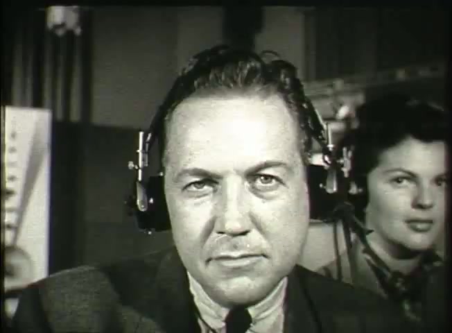 The still from 'Story Without End' features a man wearing headphones, looking intently at the camera, conveying a sense of focus and authority. A woman with a similar headset is positioned behind him, suggesting a collaborative environment. The setting appears to be a central office or control room, indicative of the telecommunications context of the late 1940s, likely highlighting aspects of the Bell System network and its operations during that period. The overall mood emphasizes professionalism and communication.