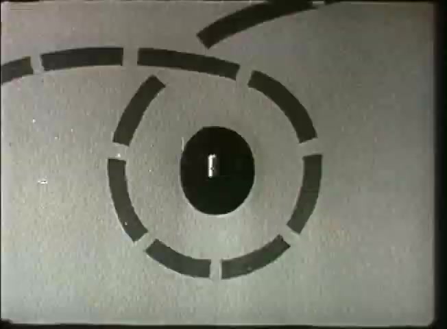 The still from 'Story Without End' features a graphic representation, likely symbolizing network connections or communication pathways. A central black circle is surrounded by a series of curved line segments, suggesting movement or transmission. The design is minimalist and abstract, characteristic of visual aids used in mid-20th century educational films to convey complex concepts, such as telecommunications, in a simplified manner. The overall aesthetic is indicative of the era's graphic style, focusing on clarity and conceptual representation related to the Bell System's communication infrastructure.