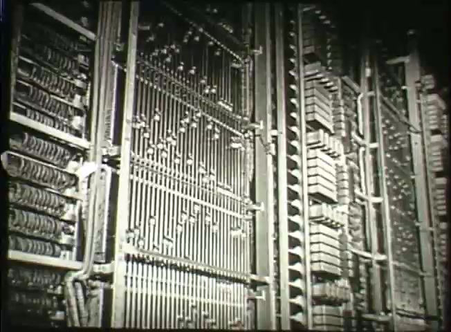 The 16mm still from 'Story Without End' features a close-up view of intricate telephone exchange equipment. The image captures a dense arrangement of wires, metal components, and relay structures typical of mid-20th century central office technology, illustrating the complexity of the Bell System's network operations in the late 1940s. The still emphasizes the mechanical sophistication of telecommunications infrastructure during that era.