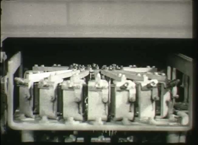 The still from 'Story Without End' depicts a series of mechanical components within a central office setting of the Bell System from the late 1940s. The image focuses on a set of switches or relay mechanisms, illustrating the intricate machinery that facilitated telephone communication at the time. This still captures the technological underpinnings of the network, emphasizing the complexity and functionality necessary for connectivity in that era.