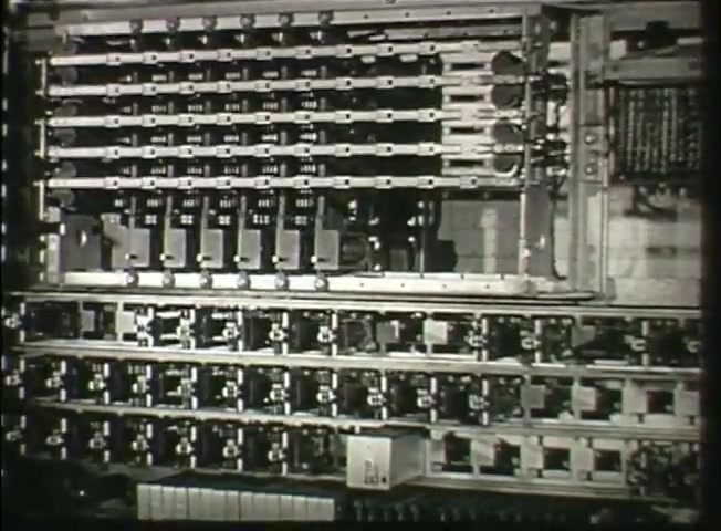 The still from 'Story Without End' showcases intricate components of a telephone switching system used by the Bell System in the late 1940s. It features a close-up of mechanical relays and circuits, illustrating the technology integral to phone networks of that era. The image emphasizes the complexity and functionality of central office equipment, highlighting the infrastructure that facilitated communication at the time.