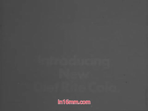 The still from the Diet Rite Cola commercial features a title card introducing the 'New Diet Rite Cola.' It is presumably from 1969, coinciding with the brand's change from cyclamate to saccharine as a sweetener. John 'Hondo' Havlicek, a notable figure from the Boston Celtics, is featured, emphasizing the commercial's appeal during that period. The aesthetic suggests a vintage look typical of late 60s advertisements.