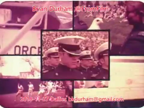 The still features a montage of images showcasing a military or ceremonial event. Central to the composition are uniformed officers, likely in a parade or official ceremony. Surrounding images include elements like an eagle, a crowd, and possibly vehicles, all rendered in a vintage color palette typical of 16mm film. The text overlay attributes the work to Brian Durham and includes a date and email for contact.