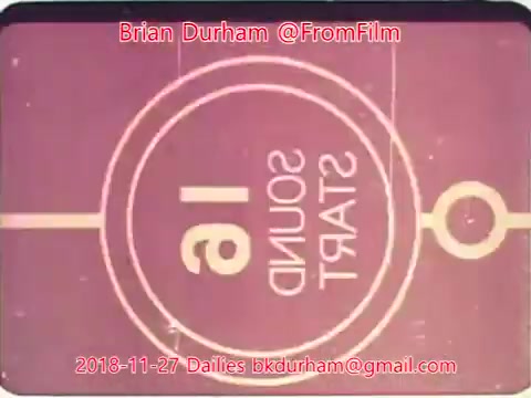 The still features a vintage film frame with a circular design displaying '16 SOUND START' in reversed text. The background has a pink hue, suggesting it's part of an older cinematic film system. It includes a timestamp from November 27, 2018, and credits to Brian Durham with contact information. The overall aesthetic conveys a nostalgic feel associated with classic filmmaking.