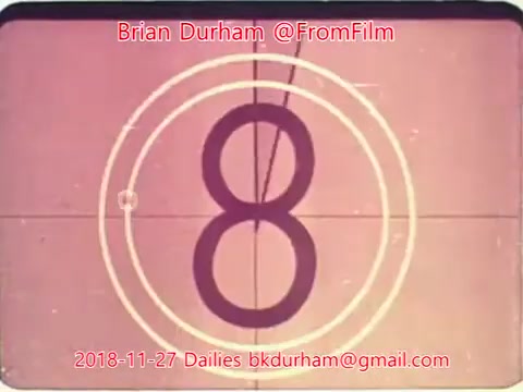 The still features a countdown format typical of film dailies, showcasing the number '8' prominently in the center. The background has a faded, vintage look, consistent with 16mm film, and is framed by concentric circles. The date and email watermark at the bottom identifies it as part of Brian Durham's dailies from November 27, 2018.