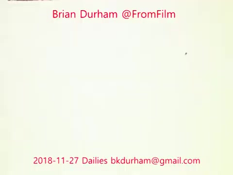 The still appears to be a frame from a 16mm film, featuring minimal visual content, primarily a pale background with text. The text includes details such as 'Brian Durham @FromFilm,' the date '2018-11-27 Dailies,' and an email address. It suggests a focus on film dailies from a specific project, likely annotating or cataloging the footage.