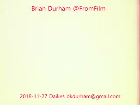 The still features a simple design with a light background and text in red. It displays the name 'Brian Durham @FromFilm,' the date '2018-11-27,' and an email address. The overall aesthetic is minimalistic, focusing on the textual information related to film dailies.