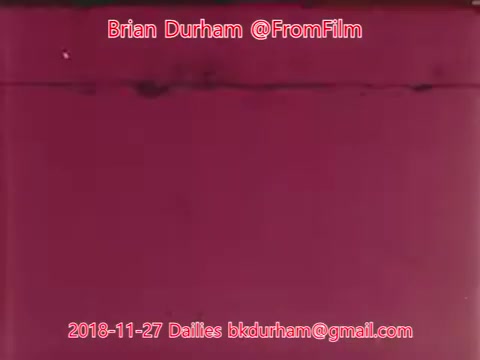 The still features a predominantly pink background with text overlay that identifies it as a 16mm film still from 'From Film Dailies' dated November 27, 2018. It includes the name Brian Durham, along with an email address and the title 'ffn035-dristan-dailies.' The image appears to focus on the formal aspects of film documentation rather than visual content.
