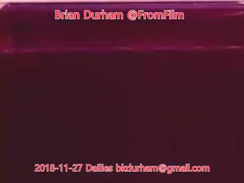 The still features a rich, deep color, predominantly a shade of purple or magenta, giving a surreal and abstract feel. Overlaid text includes the name 'Brian Durham,' the handle '@FromFilm,' and details indicating it is a 16mm film still from dailies dated November 27, 2018. The email address 'bkdurham@gmail.com' is also present at the bottom, contributing to the context of film production or archival material.