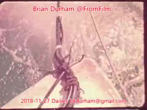 The still features a close-up view of a boat's bow, focusing on the rigging and knots. Water splashes around the vessel, indicating movement through waves. The image has a vintage quality typical of 16mm film, enhanced by a warm color palette. Text overlays identify Brian Durham and the date as November 27, 2018.
