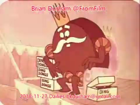 The still features a cartoon character resembling a round, anthropomorphic figure with a mustache and a crown, sitting amid boxes labeled 'DING DONGS.' The character appears thoughtful or contemplative, set against a pastel background. The overall tone suggests a whimsical or comical context, typical of animated segments from earlier periods.
