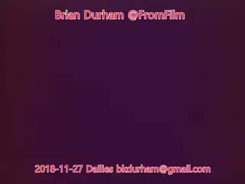 The still features text over a gradient background, indicating it is from film dailies dated November 27, 2018. The text includes the name 'Brian Durham,' the handle '@FromFilm,' and an email address. The overall visual is simple, focusing on the text rather than imagery from the film itself.