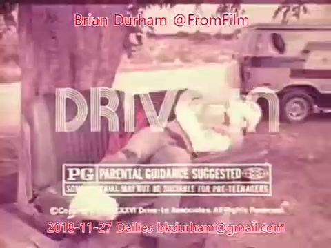 The still features a vintage 16mm film frame that has a faded quality. It prominently displays the word 'DRIVEN' in bold, stylized letters. Below the title, there’s a 'PG' rating along with a parental guidance note suggesting it may not be suitable for younger children. The background includes a tree and part of a vehicle, suggesting an outdoor or drive-in context. The overall tone is nostalgic, reflecting the period's film aesthetics.