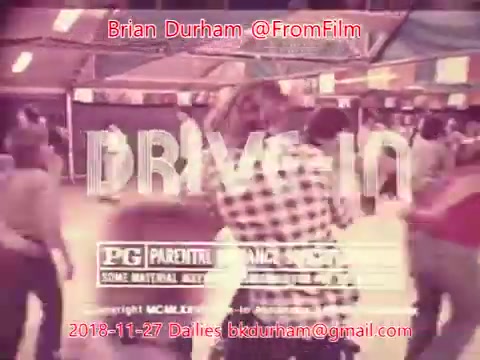 The still is from a 16mm film segment connected to '@FromFilm Dailies' dated November 27, 2018. It features a lively scene, likely depicting a social gathering or event, with people dancing or interacting in a retro setting. The word 'DRIVE-IN' is prominently displayed, along with a 'PG' rating and other production details, suggesting a focus on nostalgic or classic cinema themes.