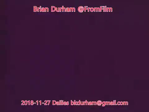 The still features a purple background with text overlay that includes the name 'Brian Durham,' the handle '@FromFilm,' and a date indicating '2018-11-27 Dailies.' The email address is also displayed. The overall aesthetic is minimalistic, focusing on the textual elements.