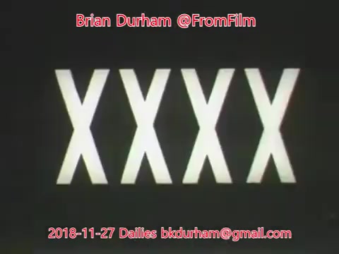 The still features a black background with bold, stylized text displaying 'XXXX' in a large, striking font. The date '2018-11-27' and contact information for Brian Durham (@FromFilm) are displayed prominently at the top and bottom of the image, respectively. The overall aesthetic suggests a vintage or retro film dailies theme.