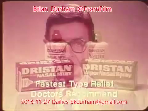 The still features a promotional image for Dristan nasal products. In the foreground, two Dristan products—Nasal Mist and Nasal Spray—are prominently displayed. Behind the products is a man wearing glasses, likely presenting the advertisement. The text highlights 'Fastest Type Relief' and 'Doctors Recommend,' emphasizing the efficacy of the product. The overall aesthetic is nostalgic, reflecting the style of advertisements from the late 20th century.